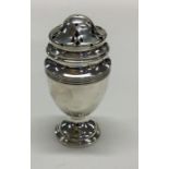 A small baluster shaped silver caster of ovoid sha