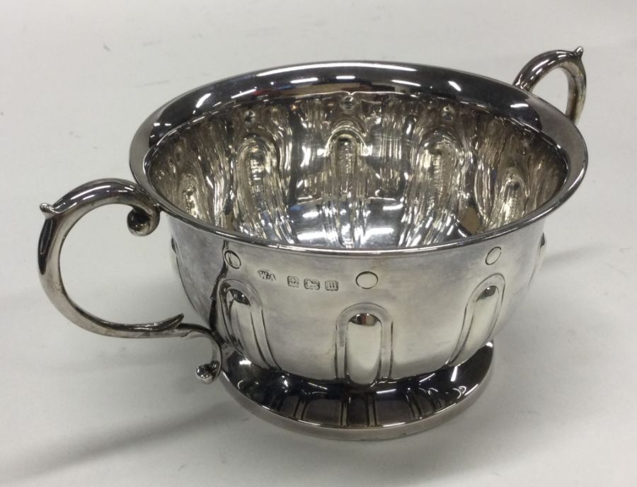 A heavy two handled silver bowl with fluted body.