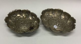 A pair of heavy silver bonbon dishes decorated wit
