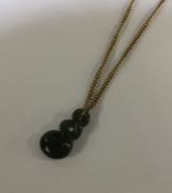 A small 9 carat necklace with hardstone pendant. A