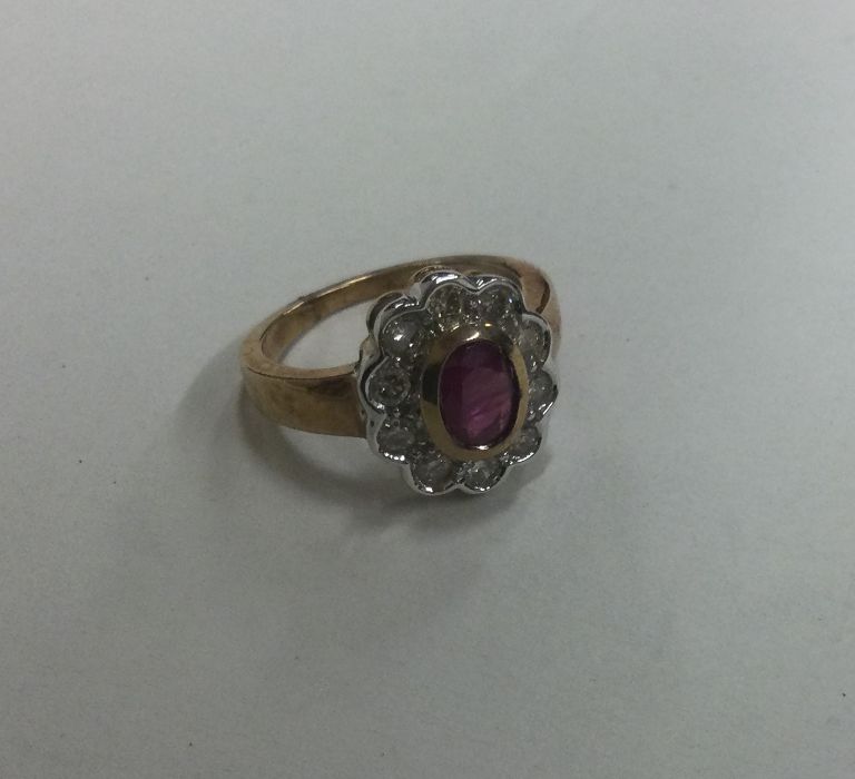 A large oval diamond and ruby cluster ring. Approx