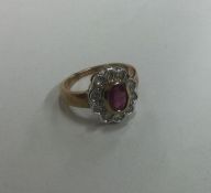 A large oval diamond and ruby cluster ring. Approx