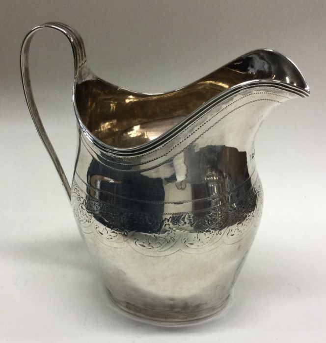 A large Georgian silver cream jug with bright cut - Image 2 of 2