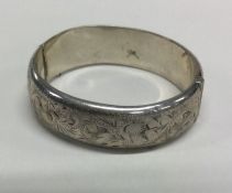 An oval silver engraved bracelet with concealed cl