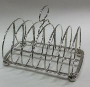 A large seven bar Georgian silver toast rack on ba