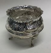 A heavy chased silver sugar bowl decorated with fl