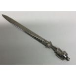 A heavy silver paper knife mounted with a warrior