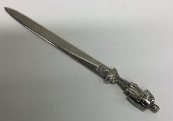 A heavy silver paper knife mounted with a warrior