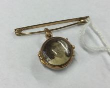 A small gold brooch together with a locket. Approx