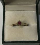 A 9 carat ruby and diamond cluster ring. Approx. 2