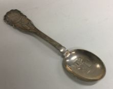 A heavy silver christening spoon decorated with 'D