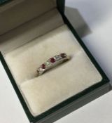 A ruby and diamond seven stone ring in 18 carat go