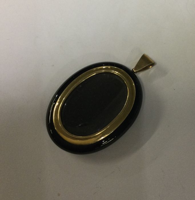 A good gold and onyx locket with loop top. Approx.