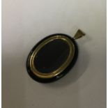 A good gold and onyx locket with loop top. Approx.