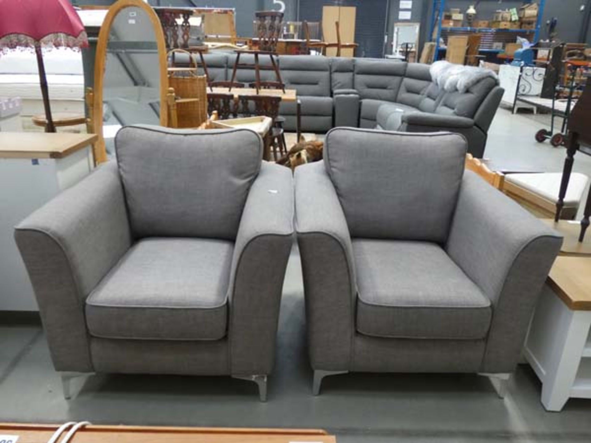 A pair of grey fabric armchairs