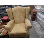 A brown floral wingback armchair