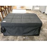 A grey fabric stowaway bed