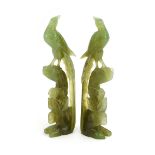 A pair of 20th century jade-type figural groups modelled as birds seated on rocky crops, h.