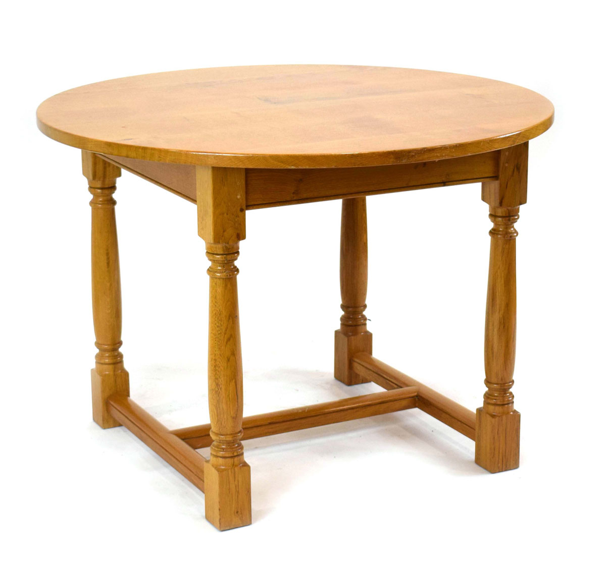 A late 20th century golden oak centre table, the circular surface on four turned supports,