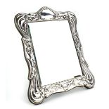 A late 20th century silver easel back table mirror, repousse decorated in the Neo-Classical manner,
