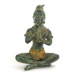 A Far Eastern green patinated bronze figure modelled as a seated musician, h.