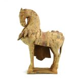 A painted Tang figure modelled as a well laden horse, on a rectangular base, h. 43.