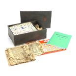 A cased bamboo and bone mahjong set together with the associated pamphlets and four tile racks