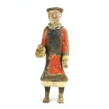 A Chinese tomb figure modelled as a standing gentleman wearing a black and red robe, h.