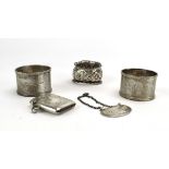 Three silver napkin rings, a silver vesta case and a silver kidney shaped decanter label,