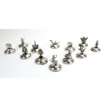 A set of twelve metalware place card/menu holders, each decorated with a Far Eastern animal,