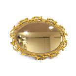 A 19th century wall mirror, the oval bevelled plate within a giltwood foliate fretwork frame,