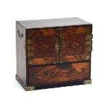 An Oriental marquetry cabinet, the two doors with brass hinges enclosing six drawers,
