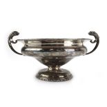 An early 20th century silver trophy vase with a pair of grotesque handles on a socle foot,