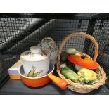 A wicker basket with pottery ornamental fruit, a Le Creuset style pot, Royal Worcester biscuit