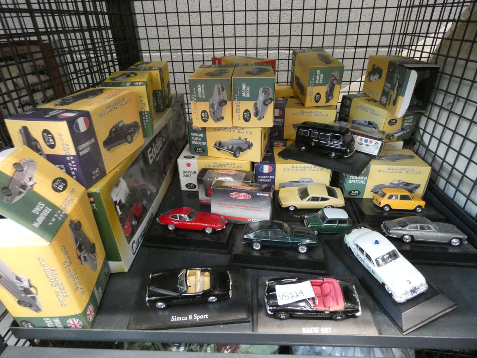 A cage containing a quantity of boxed die-cast cars