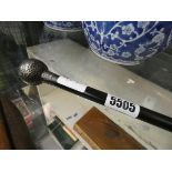 A walking cane with silver top