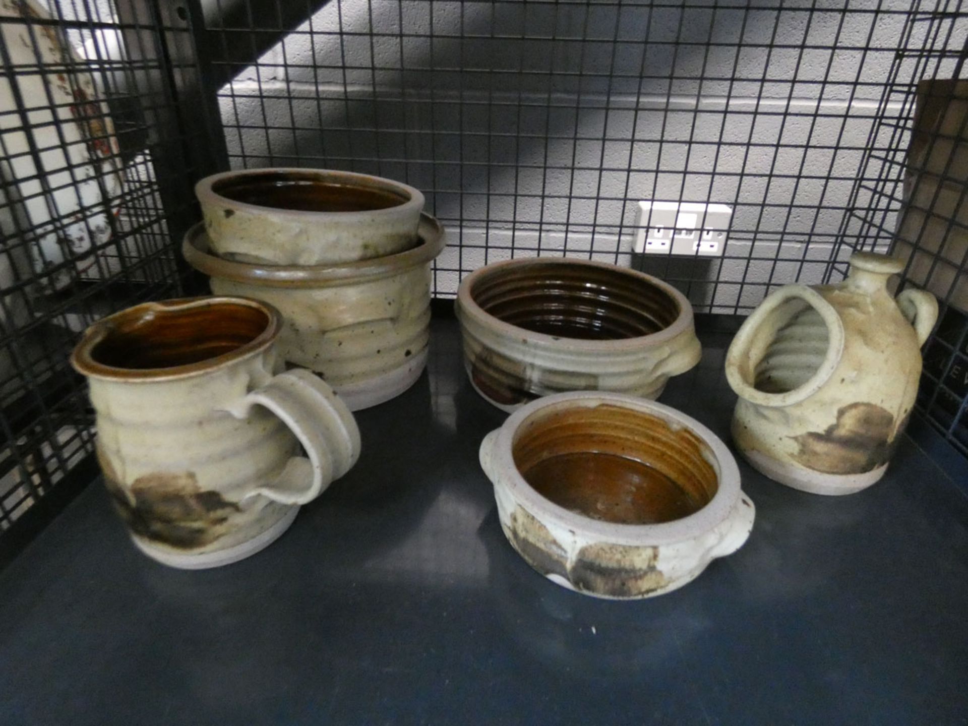 A cage containing pottery pots and a jug