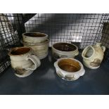 A cage containing pottery pots and a jug