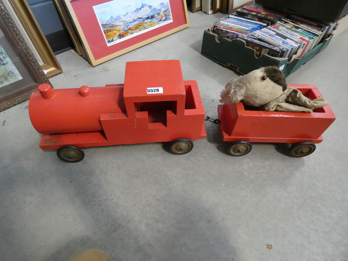 A red painted wooden child's push-along train, plus a toy dog