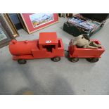 A red painted wooden child's push-along train, plus a toy dog