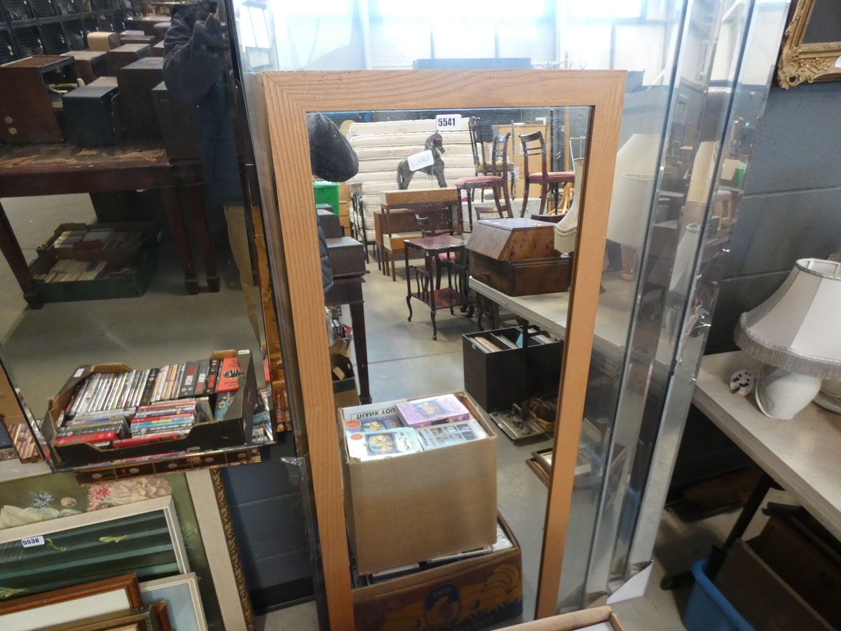 A narrow rectangular mirror in pine frame