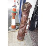 Vintage brown leather golf bag containing various vintage golf clubs