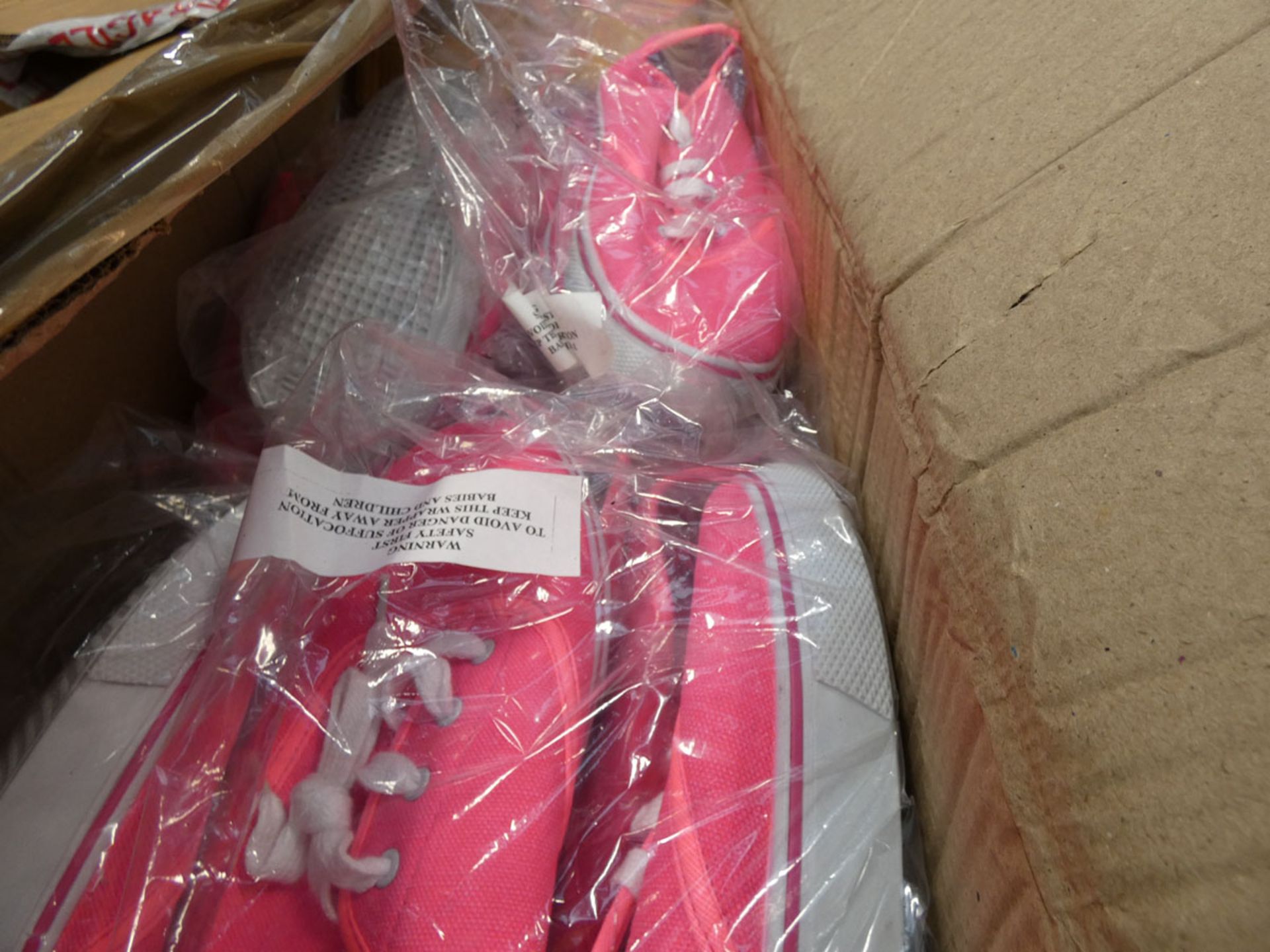 Box containing a quantity of pink and black plimsolls