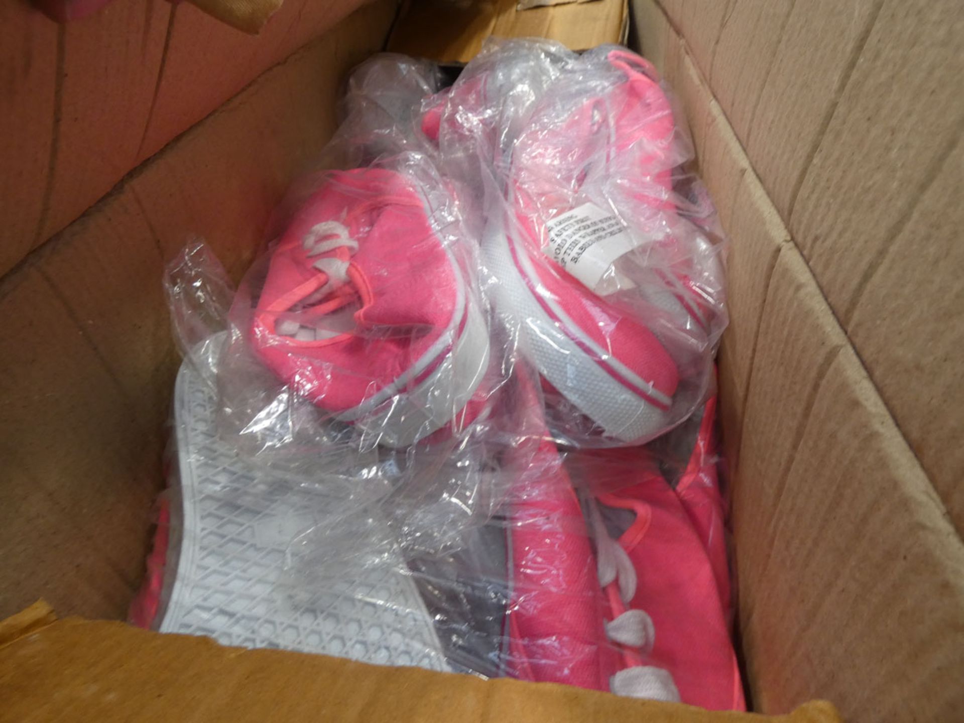 Box containing a quantity of pink and black plimsolls