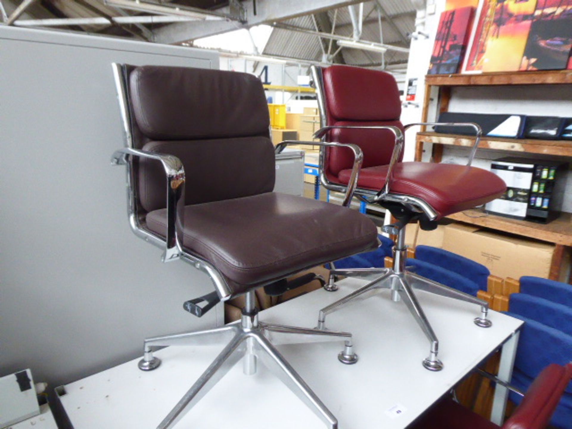 Milani Charles Eames style soft pad swivel armchairs, 1 in burgundy leather, 1 in deep brown