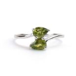 A 9ct white gold crossover ring set two teardrop demantoid garnets, by Jacques Christie,