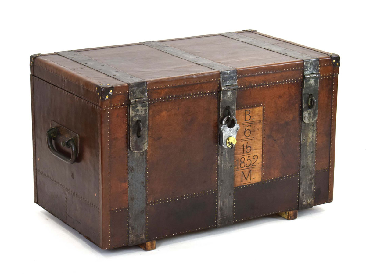 A 19th century metal bound trunk with leatherwork and brass studwork, the interior painted green,