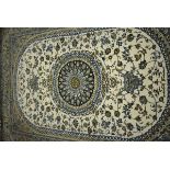 An Iranian carpet, the beige and blue ground with a central medallion,