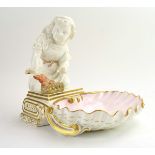 A Copeland blanc de chine and gilt decorated shell shaped dish modelled as a child warming its