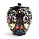 A Moorcroft ginger jar and cover decorated with stylised strawberries on a blue ground, h.